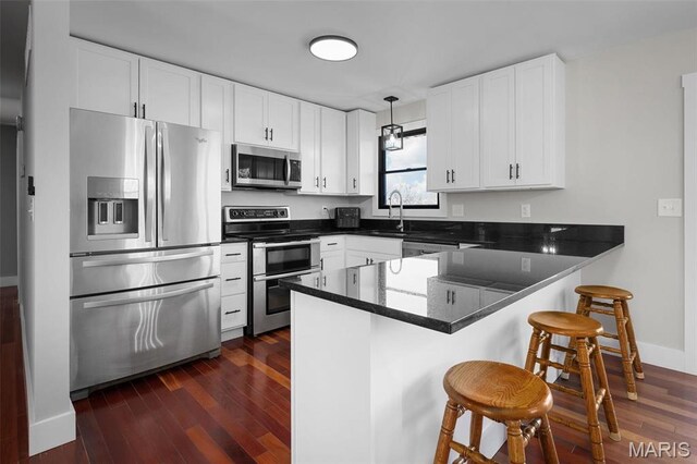719 Green Ridge Dr, Catawissa, MO 63015 - kitchen with stainless steel appliances, a peninsula, a sink, dark wood-type flooring, and white cabinetry
