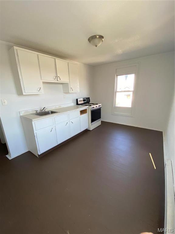 1001 Bird St, Hannibal, MO 63401 - kitchen with white stove, light countertops, and white cabinets