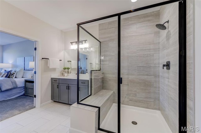 ensuite bathroom featuring a stall shower, vanity, and tile patterned flooring
