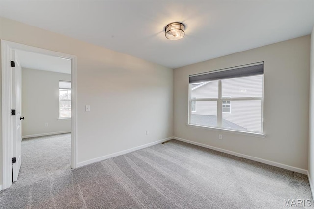 carpeted spare room with baseboards