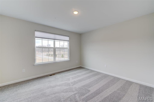spare room featuring baseboards and carpet