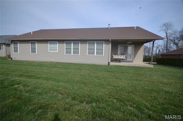 back of house with a patio and a lawn