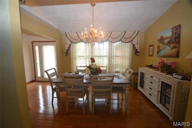 dining room featuring a chandelier, wood finished floors, and baseboards