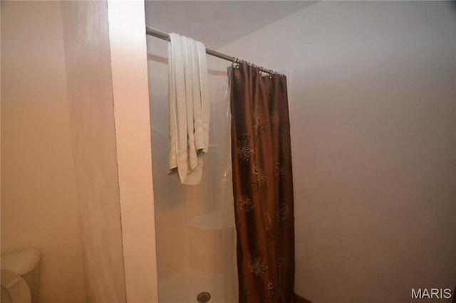 bathroom featuring a shower stall and toilet