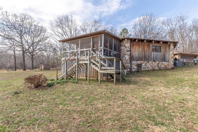64 Trails End Ln, Doniphan, MO 63935 - back of property with a sunroom, stone siding, stairs, a lawn, and central AC