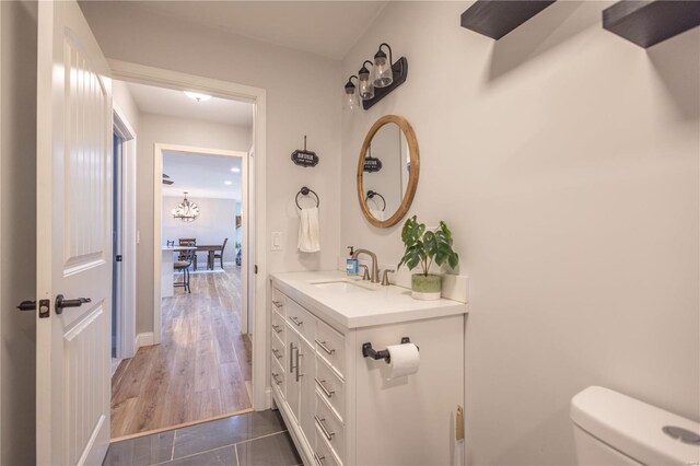 14822 Cedar Cove Pl, New London, MO 63459 - bathroom featuring vanity, toilet, baseboards, and a chandelier