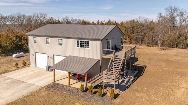14822 Cedar Cove Pl, New London, MO 63459 - back of property with concrete driveway, a deck, stairway, metal roof, and a garage