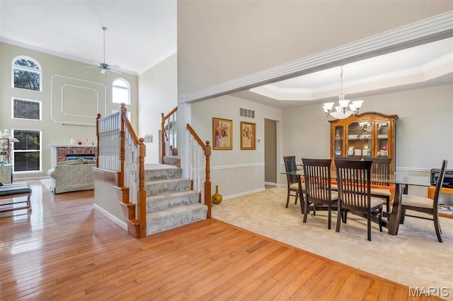 406 Clayton Hollow Dr, Wildwood, MO 63005 - dining room featuring crown molding, hardwood / wood-style flooring, stairway, a chandelier, and a fireplace
