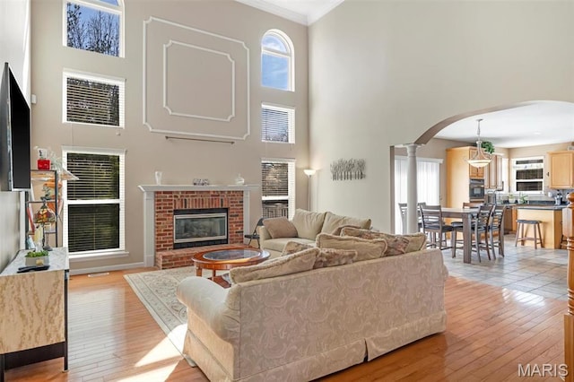 406 Clayton Hollow Dr, Wildwood, MO 63005 - living area with a towering ceiling, arched walkways, ornate columns, plenty of natural light, and light wood finished floors