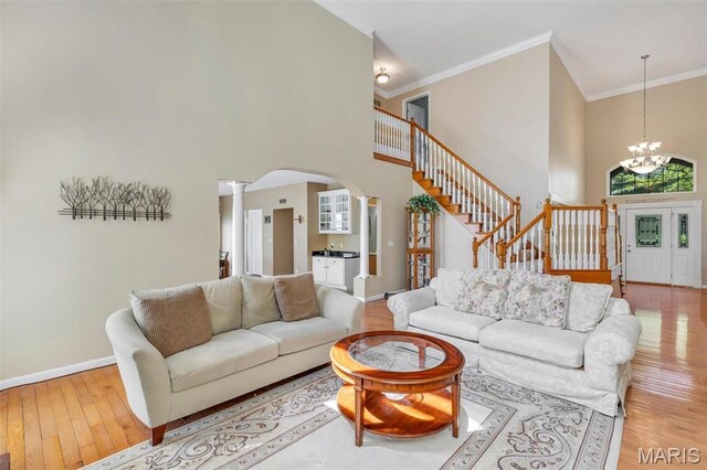 406 Clayton Hollow Dr, Wildwood, MO 63005 - living room with stairs, arched walkways, a high ceiling, decorative columns, and ornamental molding