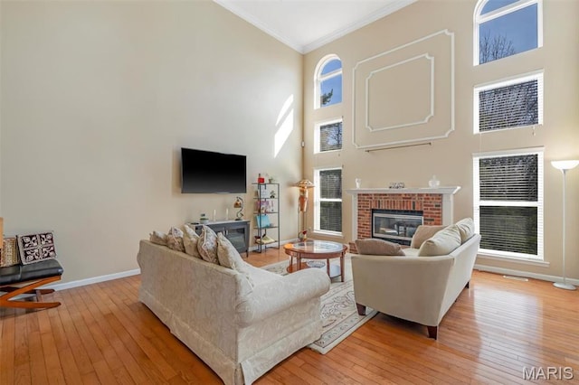 406 Clayton Hollow Dr, Wildwood, MO 63005 - living area with high vaulted ceiling, a fireplace, baseboards, ornamental molding, and light wood-type flooring
