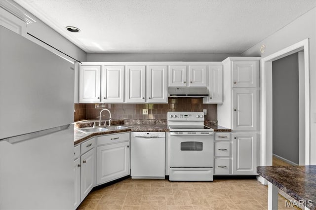kitchen with white appliances, under cabinet range hood, a sink, tasteful backsplash, and white cabinetry