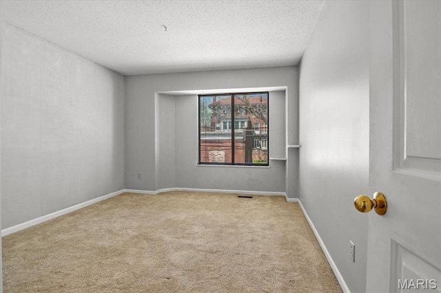unfurnished room with a textured ceiling and carpet flooring