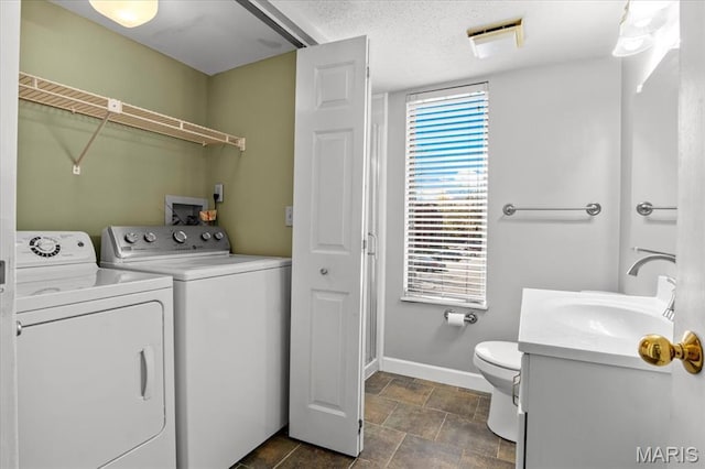bathroom featuring a closet, washing machine and dryer, baseboards, vanity, and toilet