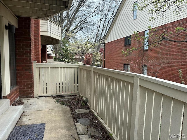 view of side of property featuring brick siding and a balcony