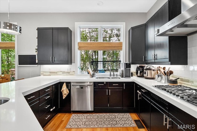 1 W Walinca, Saint Louis, MO 63105 - kitchen featuring a sink, appliances with stainless steel finishes, wall chimney range hood, light countertops, and backsplash