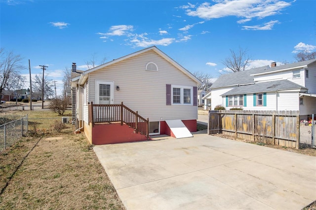 back of property with fence and a patio area