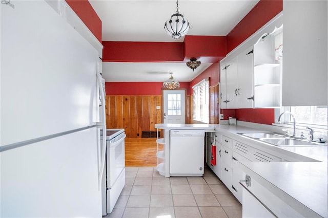 kitchen featuring white appliances, open shelves, a sink, a peninsula, and wooden walls