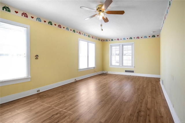 unfurnished room featuring wood finished floors, ceiling fan, and baseboards