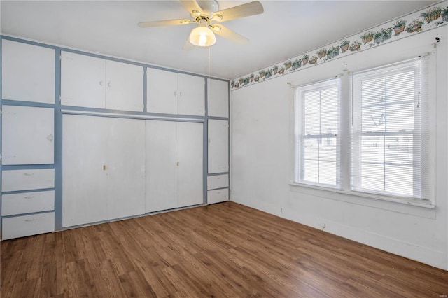 unfurnished bedroom with wood finished floors, a ceiling fan, and a closet