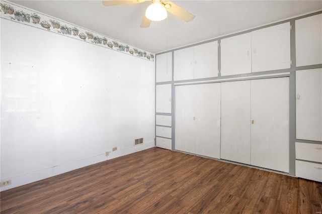 unfurnished bedroom featuring wood finished floors, a ceiling fan, and a closet