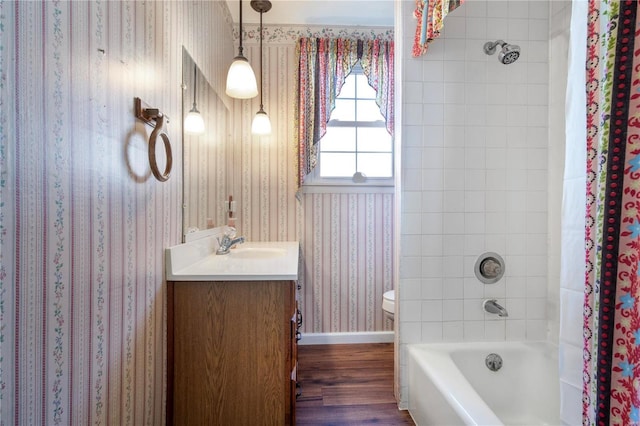bathroom with wallpapered walls, wood finished floors, toilet, vanity, and baseboards