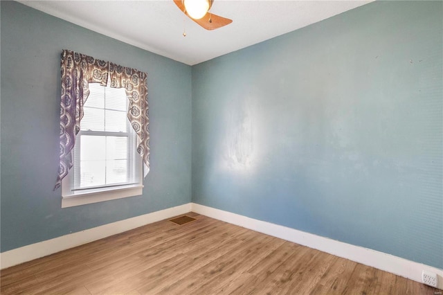 unfurnished room with baseboards, wood finished floors, and a ceiling fan