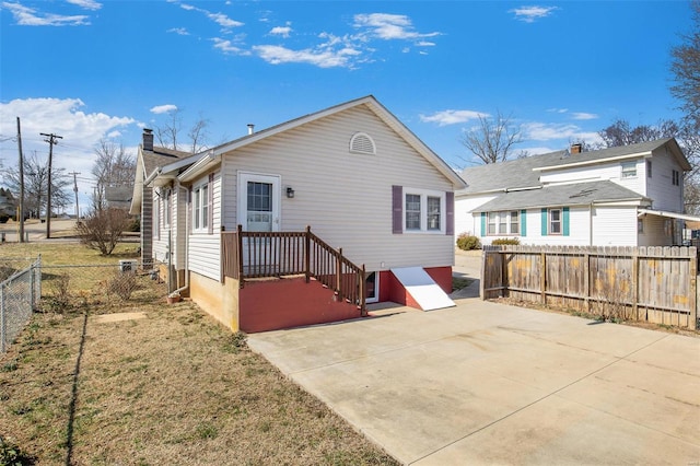 rear view of property featuring a fenced backyard and a patio area