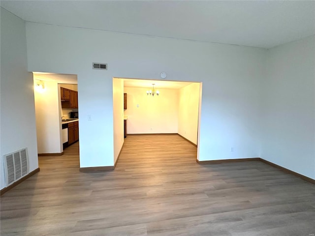 1308 Condo Dr, Rolla, MO 65401 - empty room featuring a chandelier, baseboards, and wood finished floors