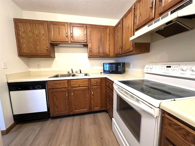 1308 Condo Dr, Rolla, MO 65401 - kitchen featuring white appliances, under cabinet range hood, a sink, light wood-style floors, and light countertops