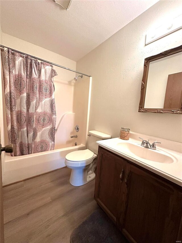 1308 Condo Dr, Rolla, MO 65401 - bathroom with wood finished floors, shower / bath combination with curtain, toilet, vanity, and a textured ceiling