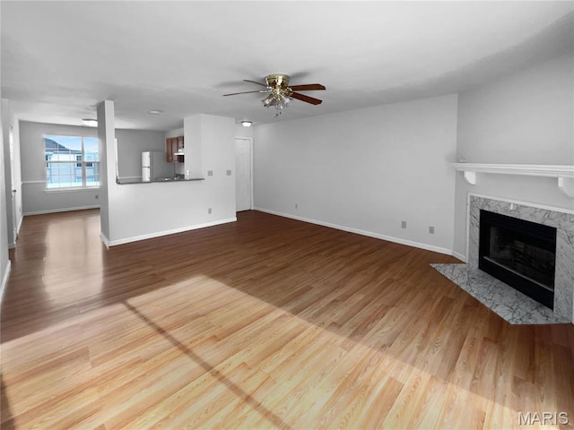 813 Sugar Valley Ct Unit 8, Saint Peters, MO 63376 - unfurnished living room featuring baseboards, a ceiling fan, a fireplace, and wood finished floors