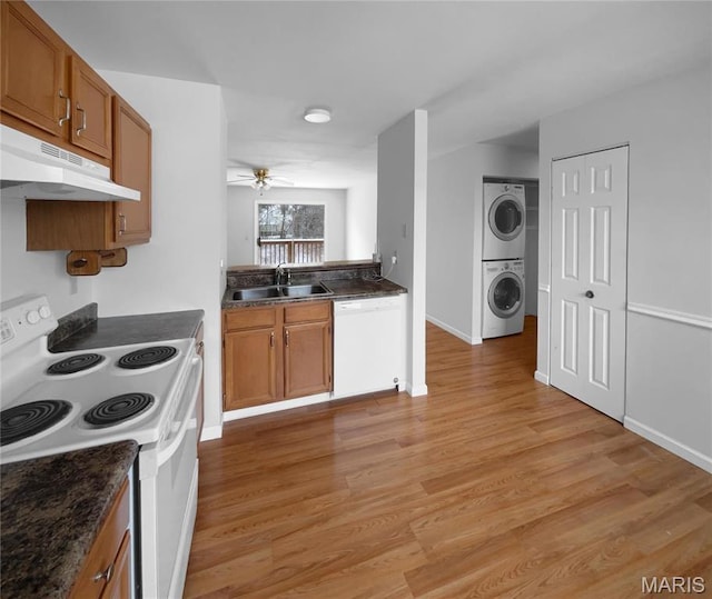 813 Sugar Valley Ct Unit 8, Saint Peters, MO 63376 - kitchen featuring white appliances, estacked washer and dryer, a sink, under cabinet range hood, and brown cabinetry