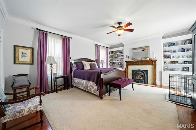 4386 Westminster Pl, Saint Louis, MO 63108 - bedroom with crown molding, a lit fireplace, wood finished floors, and a ceiling fan