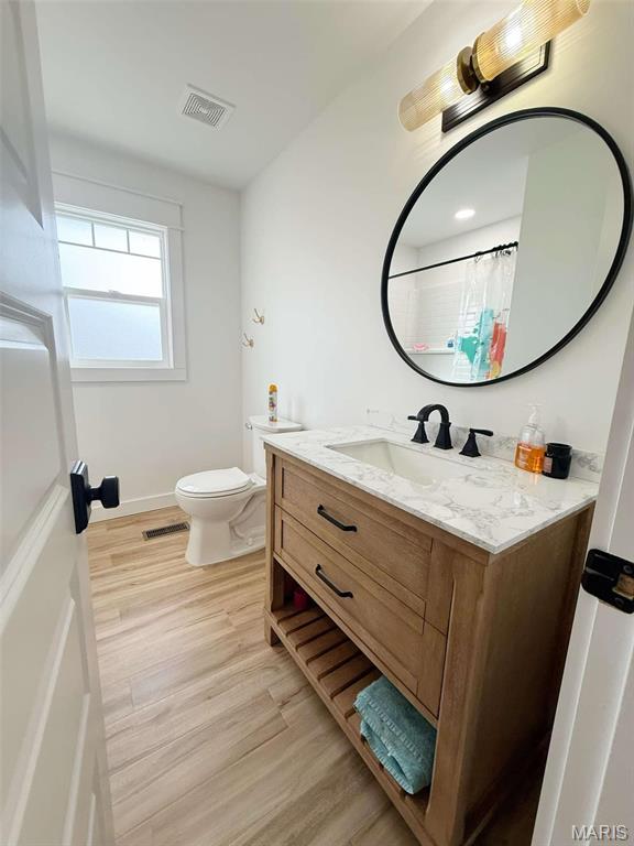 1400 S Jackson St, Salem, MO 65560 - full bath featuring toilet, wood finished floors, vanity, and baseboards