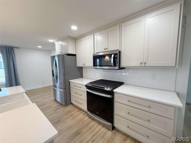 1400 S Jackson St, Salem, MO 65560 - kitchen featuring appliances with stainless steel finishes, light wood-style flooring, decorative backsplash, light countertops, and recessed lighting