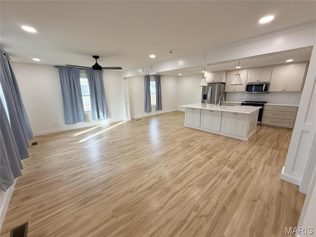 1400 S Jackson St, Salem, MO 65560 - kitchen featuring open floor plan, appliances with stainless steel finishes, light countertops, a kitchen island with sink, and recessed lighting