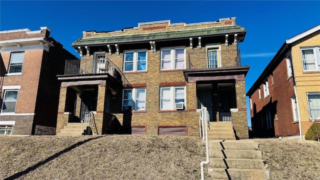 view of front of house with a balcony and brick siding