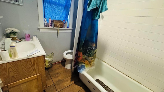 bathroom with toilet, wood finished floors, vanity, and shower / bath combination with curtain