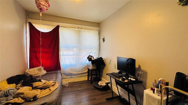 bedroom featuring wood finished floors and baseboards