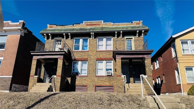 view of front of property featuring a balcony and brick siding