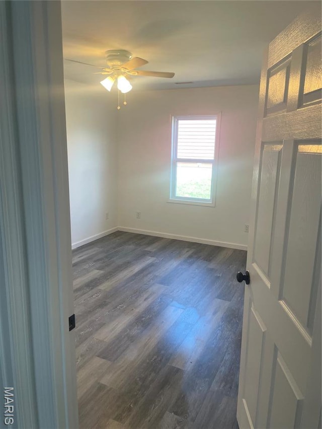 806 E Dover St, Monroe City, MO 63456 - unfurnished room with baseboards, a ceiling fan, and dark wood finished floors
