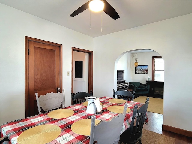 305 Williams St, Washington, MO 63090 - dining space featuring arched walkways, ceiling fan, and wood finished floors