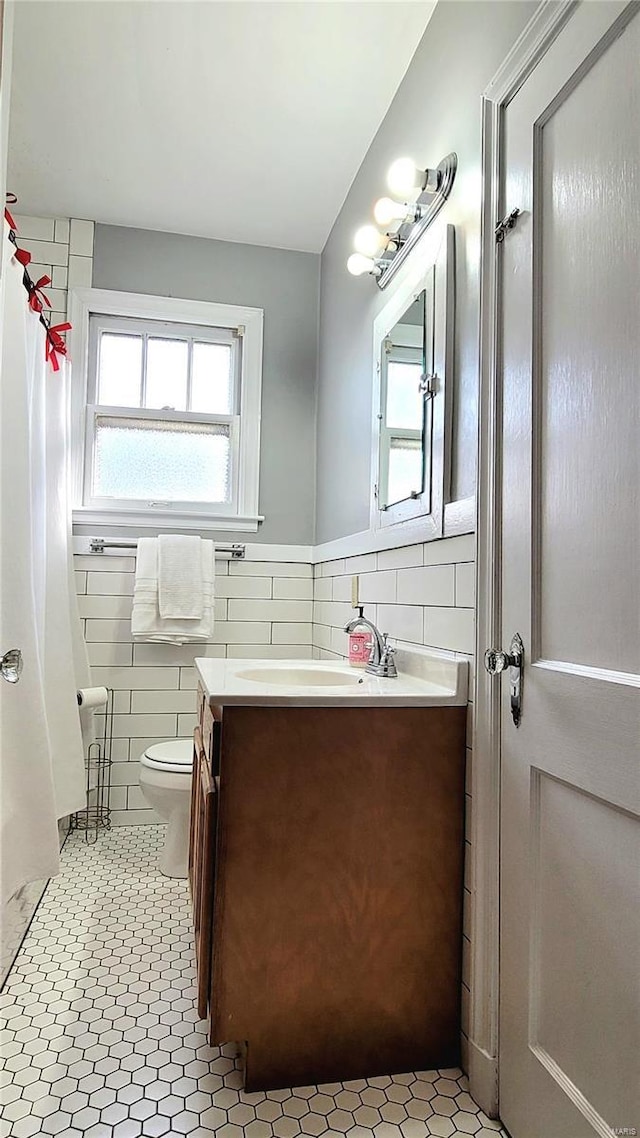 305 Williams St, Washington, MO 63090 - bathroom with tile walls, vanity, toilet, and a wainscoted wall