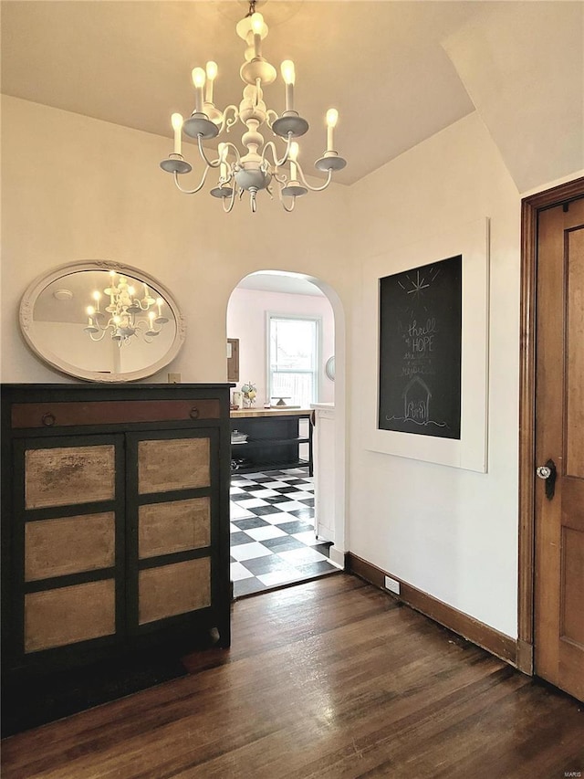 305 Williams St, Washington, MO 63090 - foyer with a chandelier, arched walkways, baseboards, and dark wood-style floors