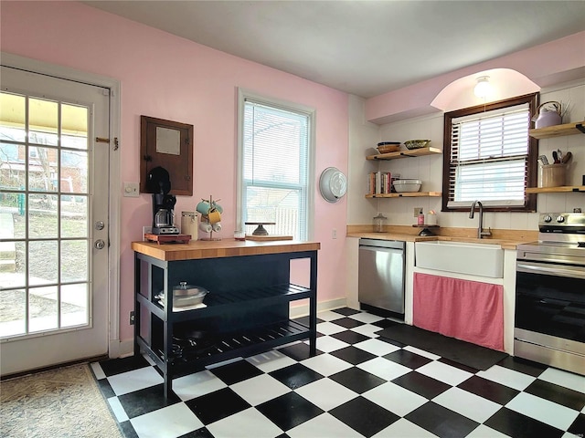 305 Williams St, Washington, MO 63090 - kitchen with appliances with stainless steel finishes, open shelves, butcher block countertops, light flooring, and a sink