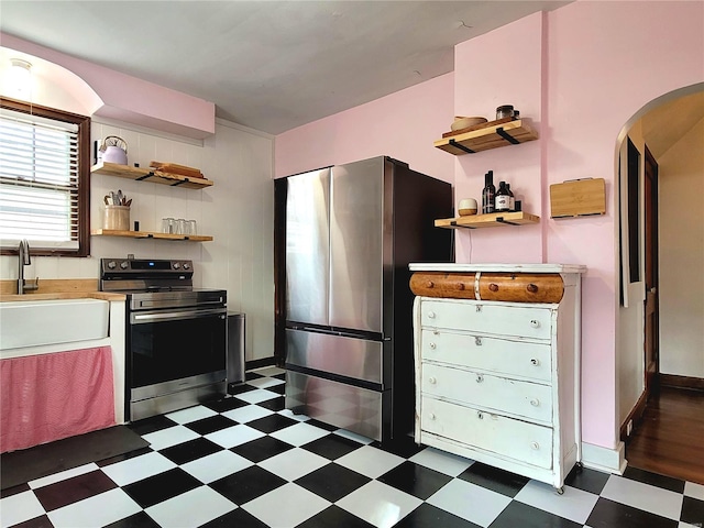 305 Williams St, Washington, MO 63090 - kitchen with stainless steel appliances, open shelves, dark flooring, and arched walkways