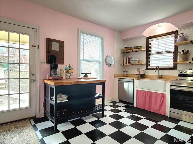305 Williams St, Washington, MO 63090 - kitchen with appliances with stainless steel finishes, open shelves, wooden counters, and tile patterned floors