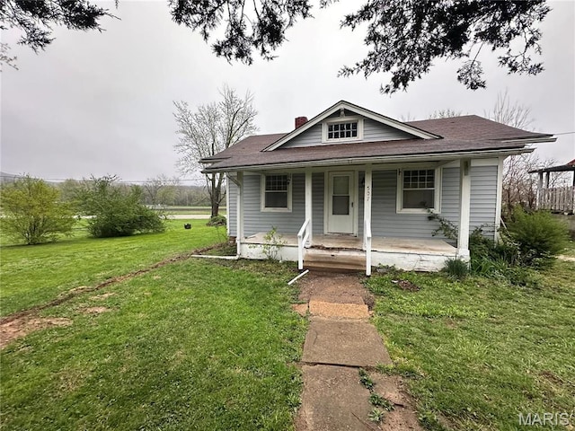 507 N Knob St, Ironton, MO 63650 - bungalow with a chimney, a front lawn, covered porch, and roof with shingles