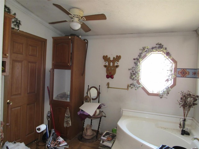bathroom with a ceiling fan, a bath, and crown molding